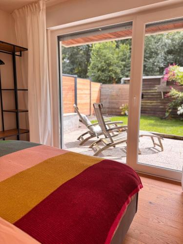 a bedroom with a bed and a sliding glass door at Lieblingsbude Homberge in Ennepetal
