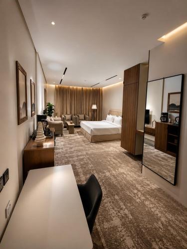 a hotel room with a bed and a living room at فندق وايت ويفس White Whiffs Hotel in Ad Darb