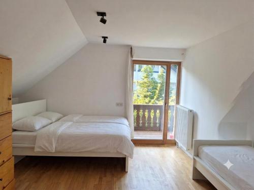 a bedroom with two beds and a large window at Central Starnberg and surrounded by nature in Starnberg