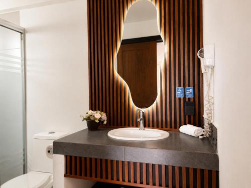 a bathroom with a sink and a mirror at Vista Zacatlan Hotel in Zacatlán