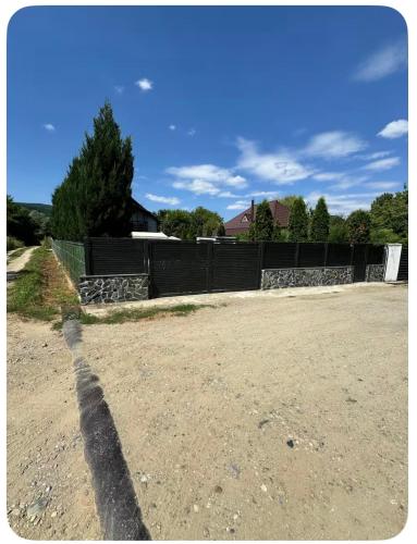 a shadow of a fence on a dirt road at Casa Fred in Sîmbotin