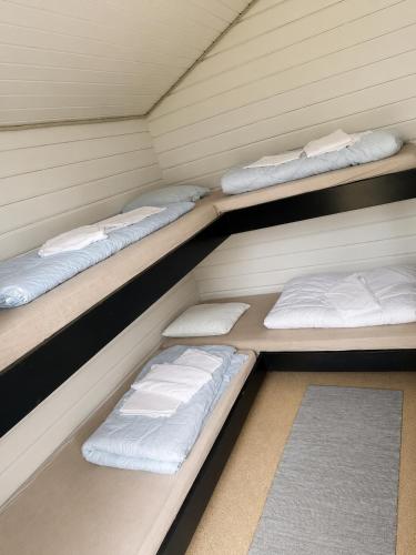 a row of three bunk beds in a room at Rudbøl Naturcamping in Højer