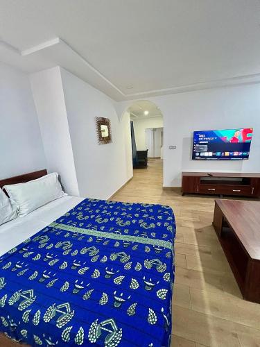 a bedroom with a bed and a flat screen tv at Tchaopremium in Lomé