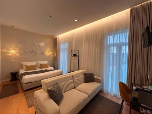 a living room with a couch and a bed at Pedra de Sal Hostel & Suites in Rio Maior