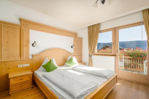 a bedroom with a bed and a large window at Residence Diana Apartment 102 in Terento