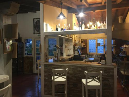 a bar with two white stools in a restaurant at Posada rural el rincón de Cabrojo in Cabrojo
