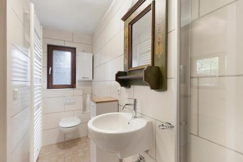 a white bathroom with a sink and a toilet at Urlaubsoase am Bruchsee in Templin