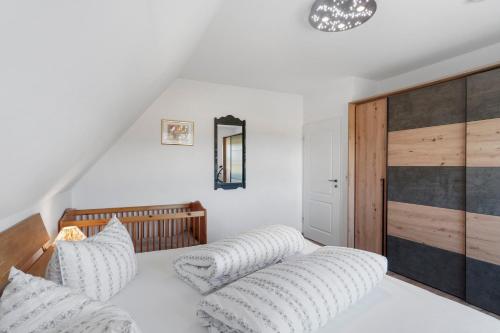 a white bedroom with a bed with white pillows at Fewo Tief Blick in Dornum