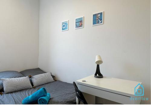 a bedroom with a bed and a desk with a lamp at Seaside Room in Gdynia