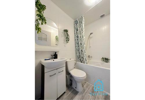 a white bathroom with a toilet and a sink at Seaside Room in Gdynia