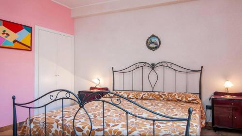 een slaapkamer met een bed en twee nachtkastjes met lampen bij Casa indipendente con ampia veranda in Portopalo