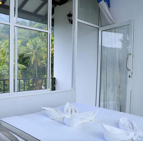 a white bathroom with a window and a sink at HILL SIDE RESORT - Ella in Ella