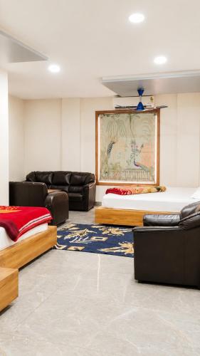 a room with two beds and couches and a rug at Jhankor Hotel in Sīkar