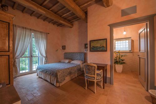 a bedroom with a bed and a desk and a window at Le Logge Ritrovate in Acquasparta