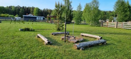 a group of logs in a field with a fence at Kempings Roja in Roja