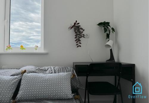 a bedroom with a desk and a chair and a window at Robot Room in Gdynia