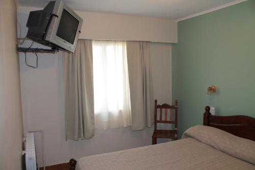 a bedroom with a bed and a television on a wall at Cabo Vírgenes in Río Gallegos