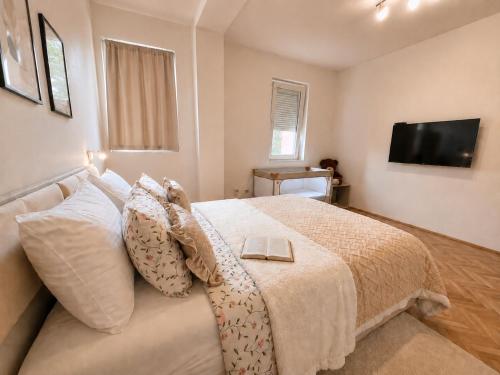 a bedroom with a bed with a television on the wall at Green Paradise in Vrnjačka Banja