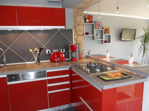 une cuisine avec des armoires rouges et un évier dans l'établissement A Mandria, à Porticcio