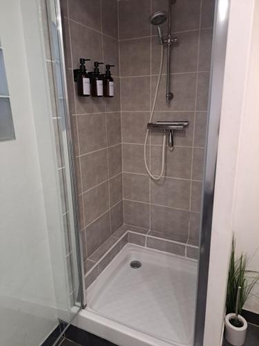 a shower with a glass door in a bathroom at LA PETITE MAISON in Beauvais
