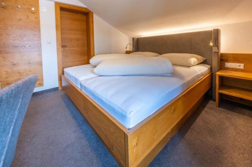 a bedroom with a large bed with a wooden headboard at Haus Hubertus in Galtür