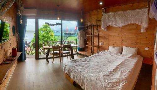 a bedroom with a bed and a table and a balcony at A Thía homestay in Diện Biên Phủ