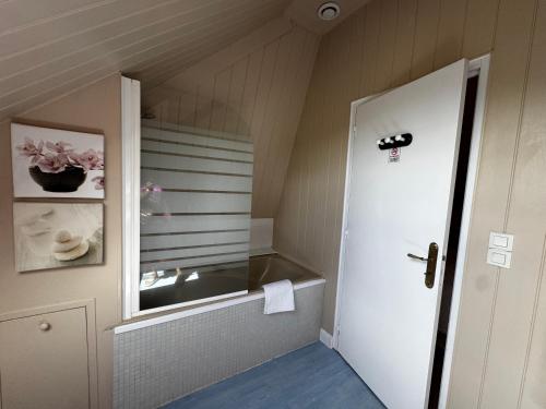 a bathroom with a window and a white door at Le Moulin de l`Epinay in Sainte-Beuve-en-Rivière
