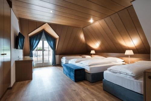 two beds in a room with a wooden ceiling at Residence Villa Stella in Ortisei