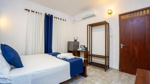 a bedroom with a bed and a mirror and a door at Sansevieria Homestay in Sigiriya