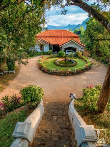 a house with a pathway leading into a yard at Kithulvilla Holiday Bungalow in Kitulgala
