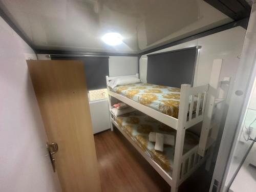 a small room with a bunk bed and a ladder at La Casita in Seville
