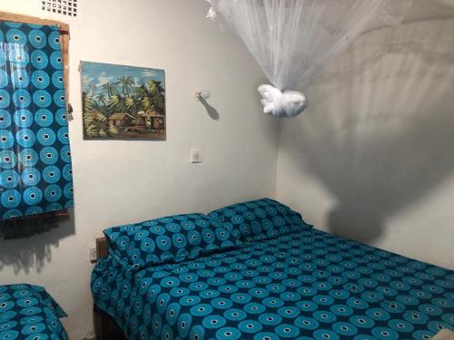 a bedroom with a blue bed and a painting at Tiko Community Centre in Saint Francis