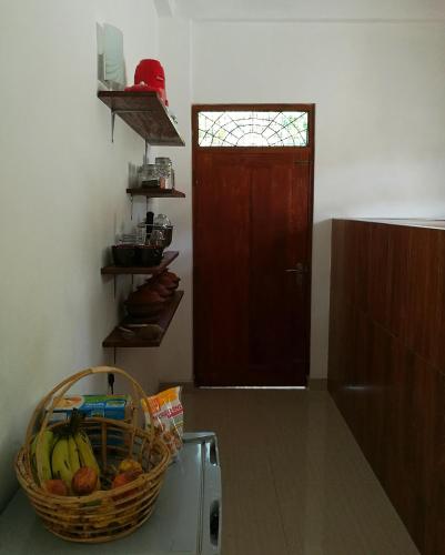 a kitchen with a basket of bananas on top of a refrigerator at Guesthouse Dilush in Beruwala