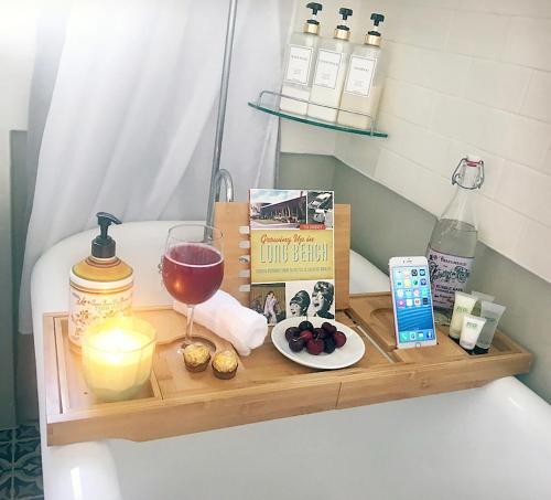 a wooden tray with a glass of wine and a candle at Casita Gundry- Boutique Hideaway, Quaint Historic Charm in Long Beach