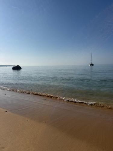 a beach with a sail boat in the water at Sofiamarholidays - Casa Praia Mar in Portimão
