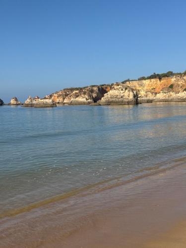 a beach with some rocks in the water at Sofiamarholidays - Casa Praia Mar in Portimão