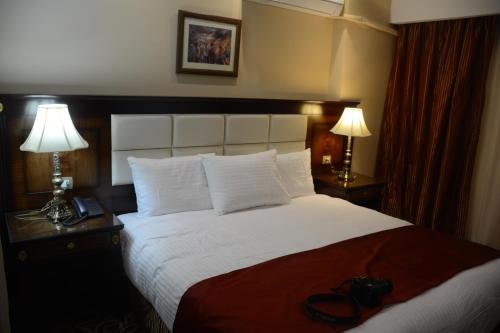 a hotel room with a large bed with two lamps at The Guard Hotel in Cairo