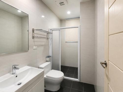 a bathroom with a toilet and a sink and a shower at Hai Jing Man Lu B&B in An-hsia