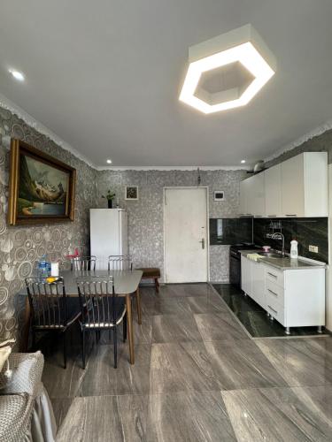 a kitchen and dining room with a table and a refrigerator at მყუდრო აპარტამენტი ანაკლიაში, Cozy Apartment in Anaklia in Zugdidi