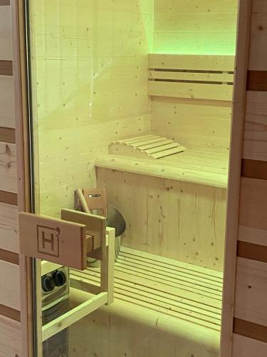 a small wooden bed in a room with a light at Le Mas de Sòmi in Aubais