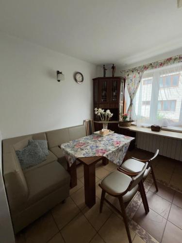 a living room with a couch and a table and chairs at Wypoczynek pod leszczynami in Sitno