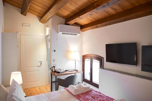 1 dormitorio con 1 cama y TV en la pared en Sopra Le Mura, en Castellammare del Golfo