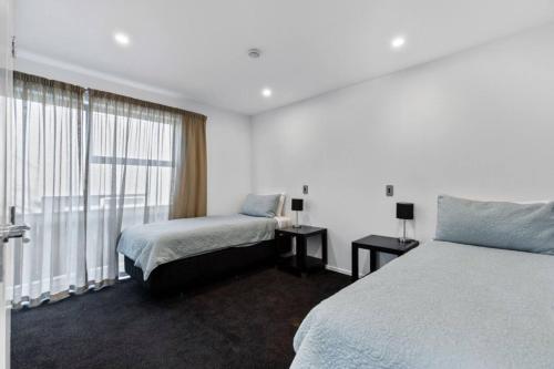 a hotel room with a bed and a window at Resort-Style 2BR Alpine Apt | Pool, Spa & Garage in Wanaka