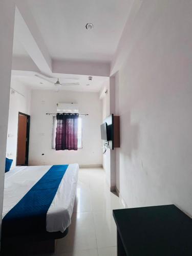 a bedroom with a bed and a tv on the wall at Hotel Viny villa in Udaipur