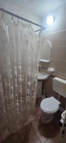 a bathroom with a toilet and a shower curtain at Атлас in Byala