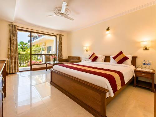 a bedroom with a large bed and a large window at juSTa Riverside Resort Srinagar in Devaprayāg