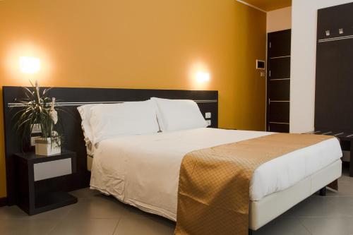 a bedroom with a large bed and a yellow wall at Hotel Panama Majestic in Rimini