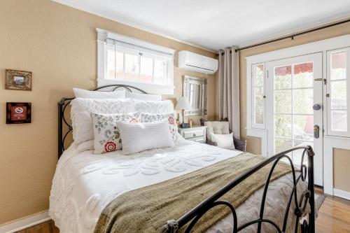 a bedroom with a bed with white sheets and pillows at Casita Gundry- Boutique Hideaway, Quaint Historic Charm in Long Beach