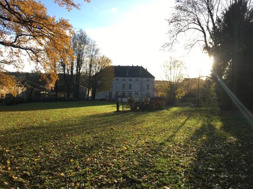 a large field with a white house in the background at Joie de Vivre in Doulevant-le-Château
