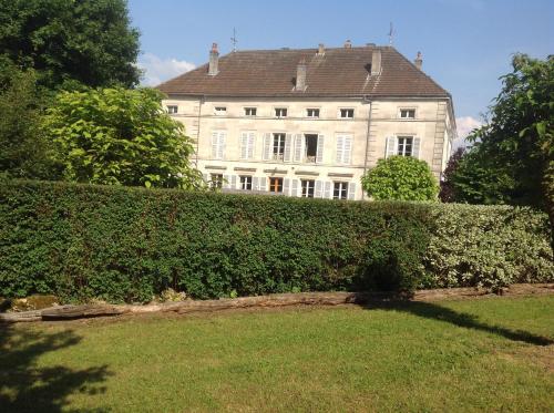 a building behind a hedge in front of a building at Joie de Vivre in Doulevant-le-Château